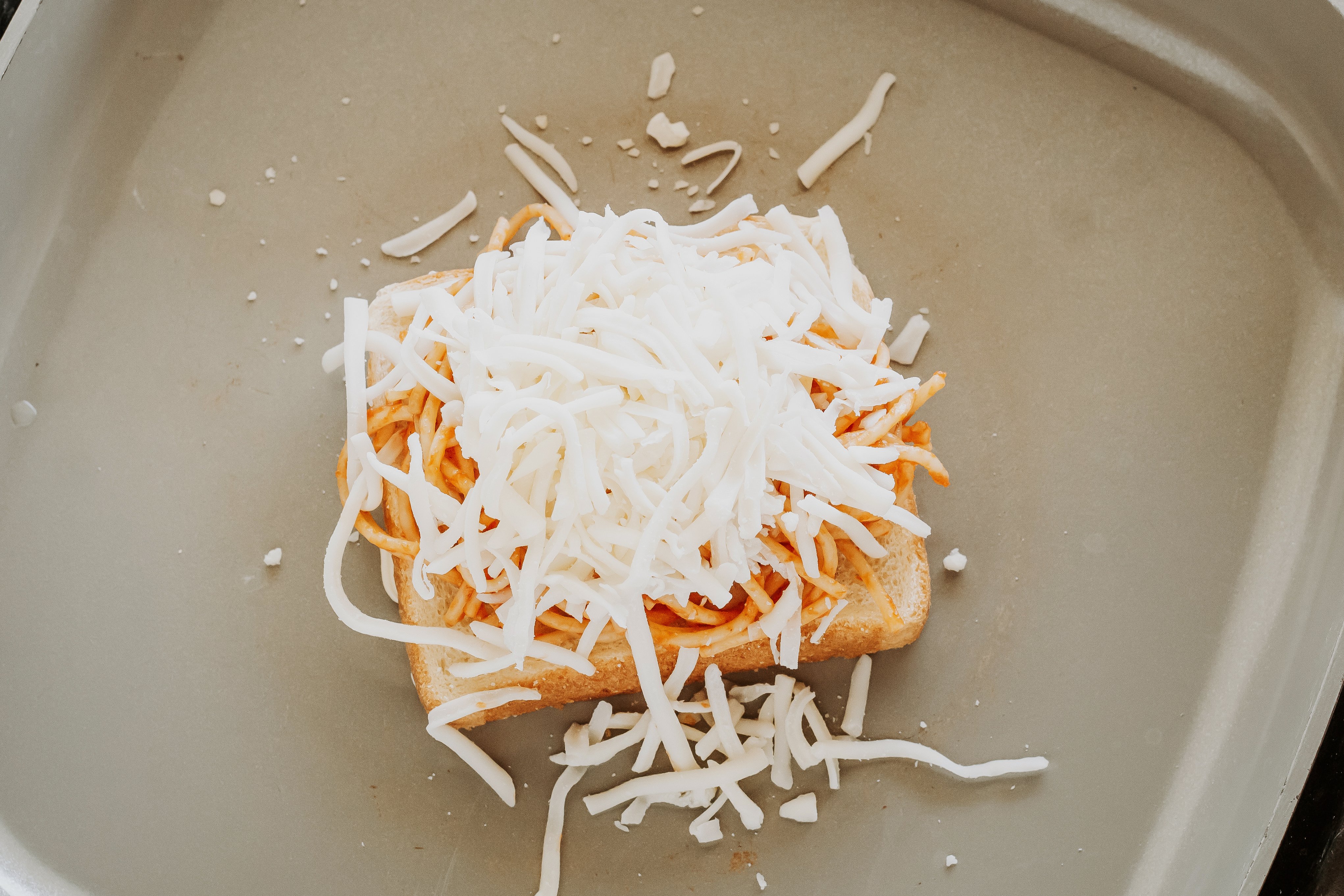 spaghetti and cheese on buttered toast