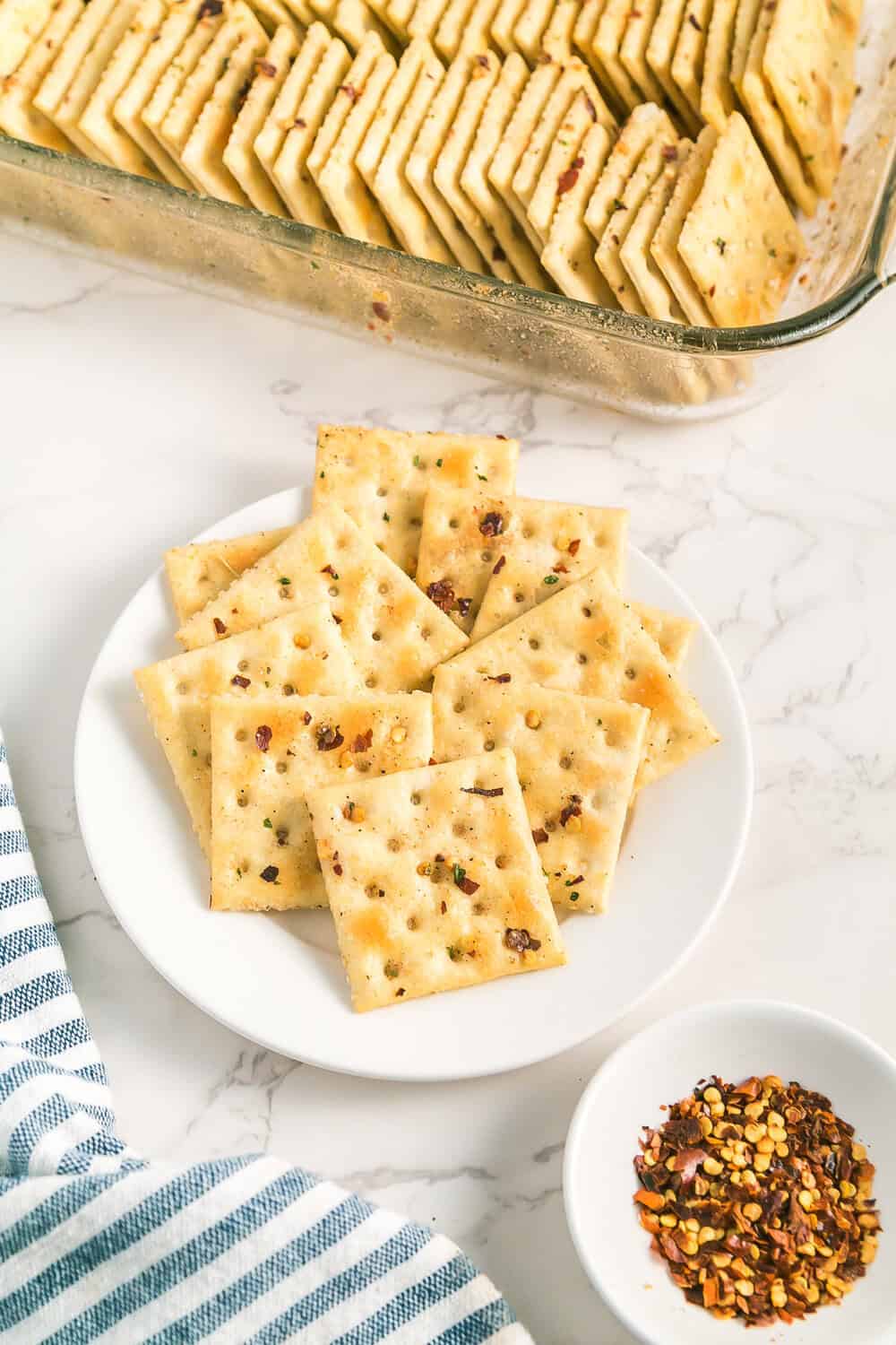 spooning seasoning mix over rows of saltine crackers