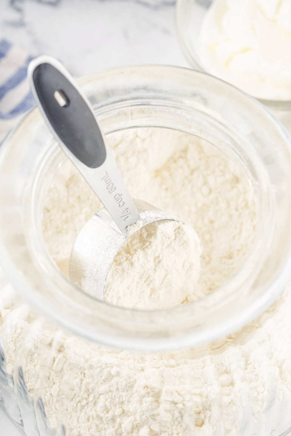 homemade biscuit mix in a container with a measuring cup
