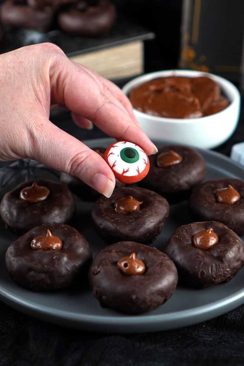 adding eyeball to mini chocolate donut