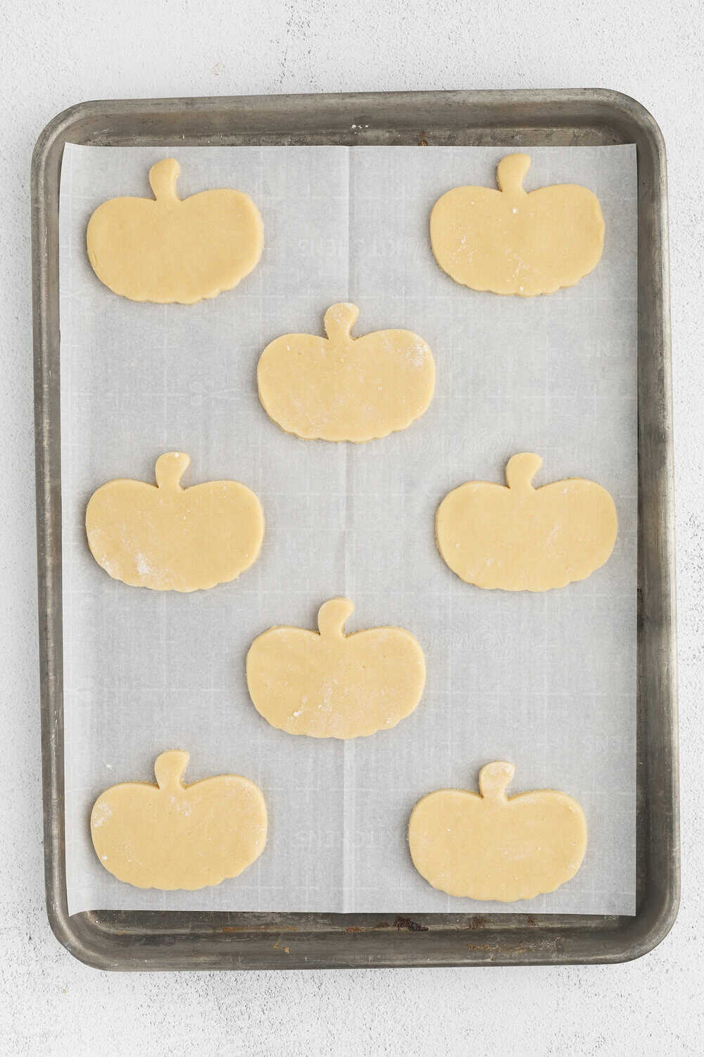 uncooked pumpkin cookies on a baking sheet lined with parchment paper