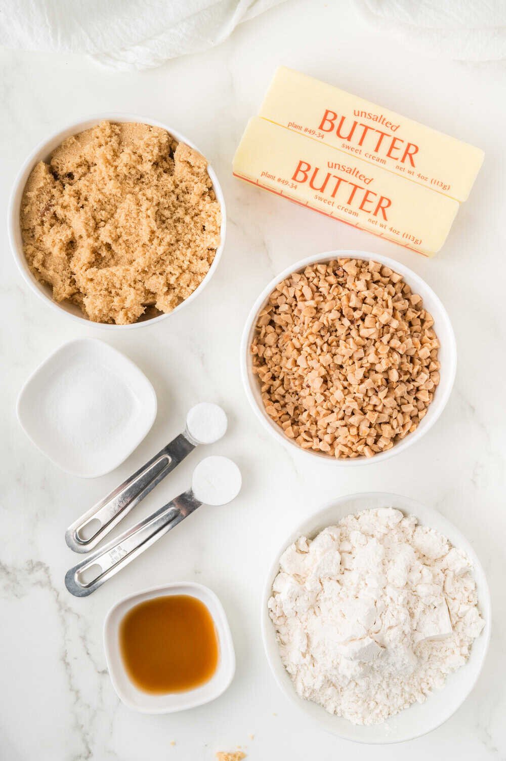 butter crunch cookies ingredients in bowls and spoons on a white surface