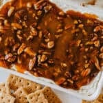 pecan pie dip in a white dish surrounded by cinnamon graham crackers