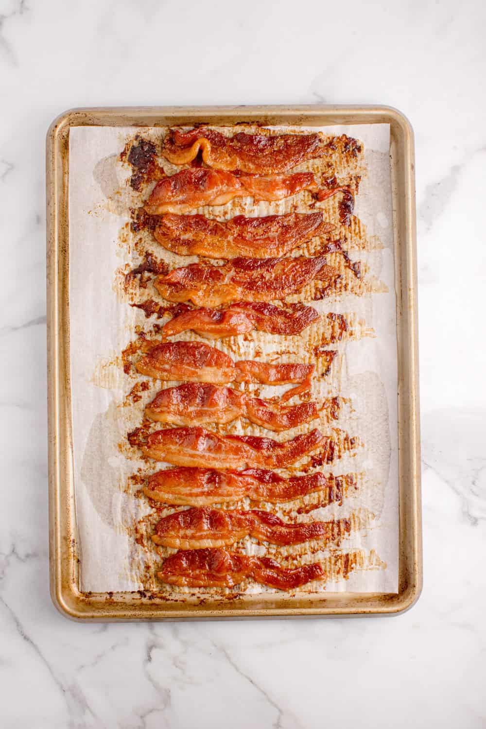 baked thick-cut bacon on a baking sheet lined with parchment