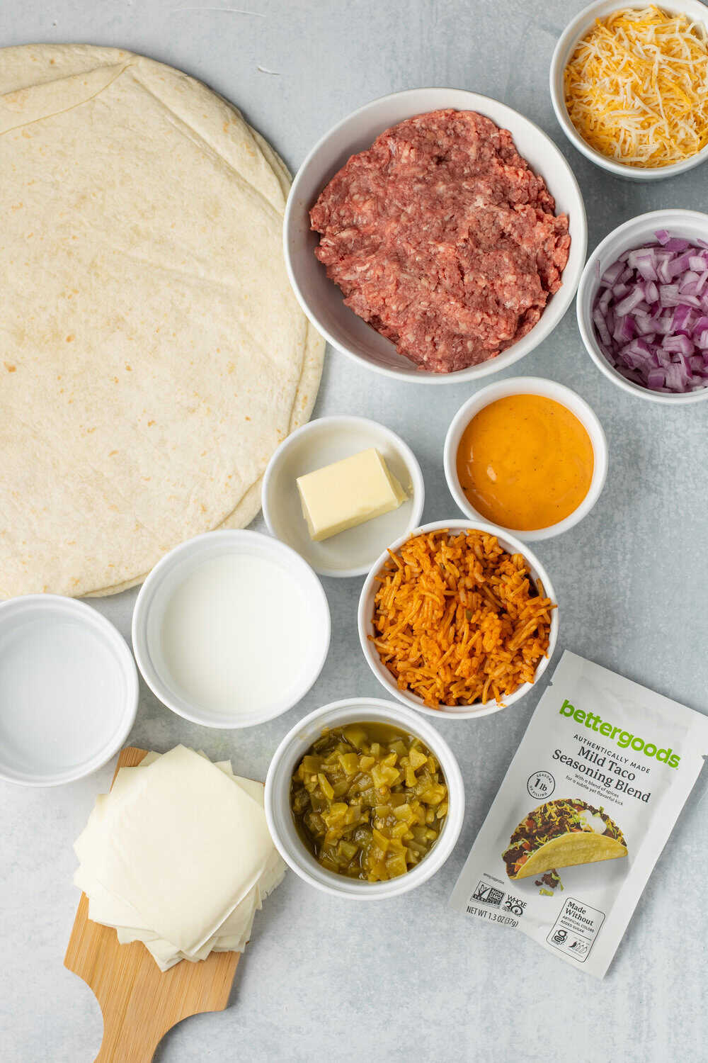 grilled cheese queso ingredients in small bowls on a white surface