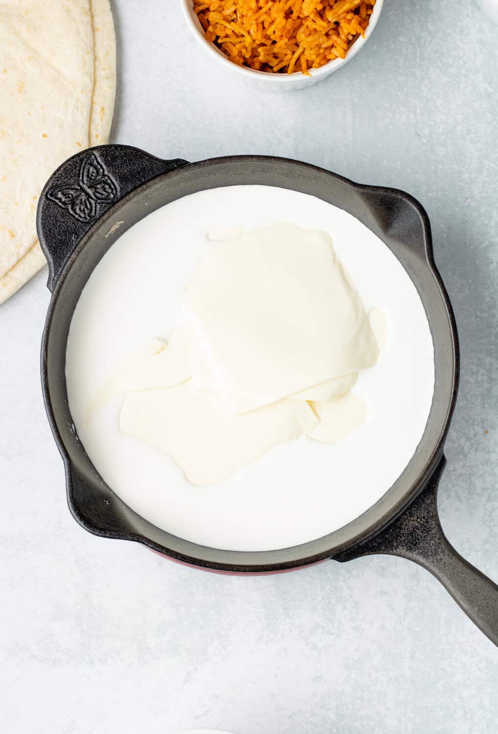 half and half with american cheese slices in a skillet for mexican queso dip