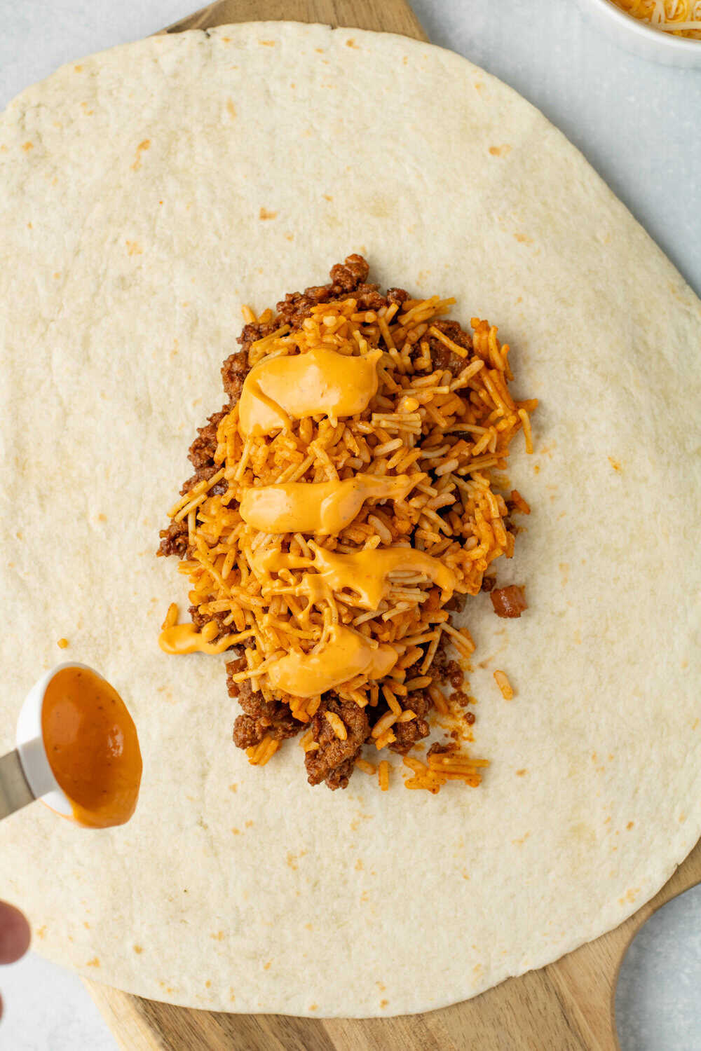 large burrito with meat, rice, and chipolte sauce on a burrito