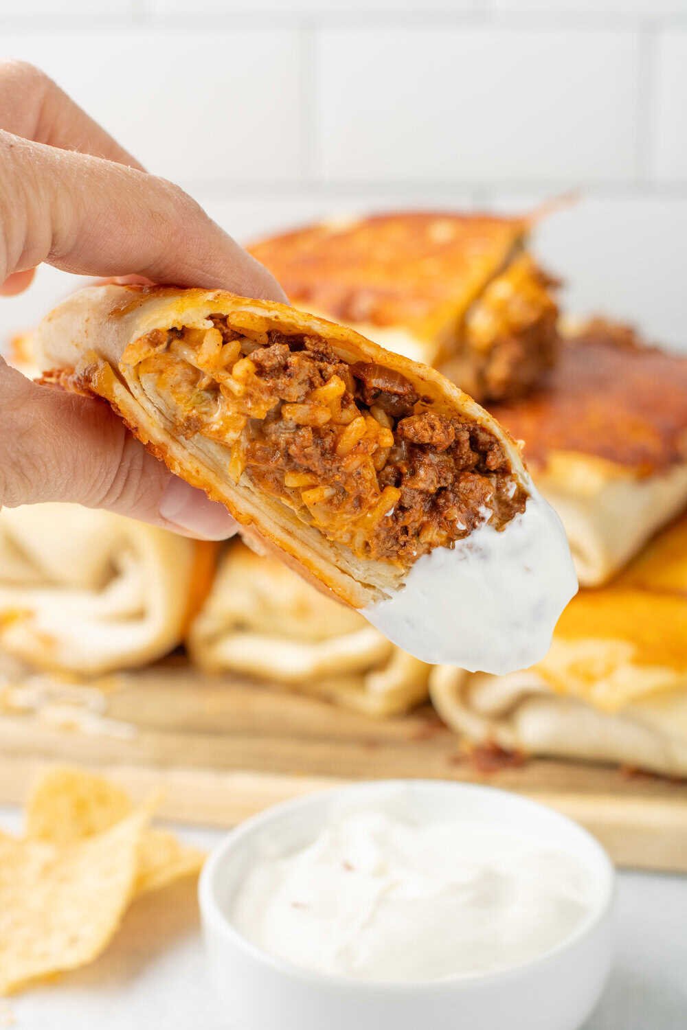grilled cheese burrito cut in half and dipped in sour cream