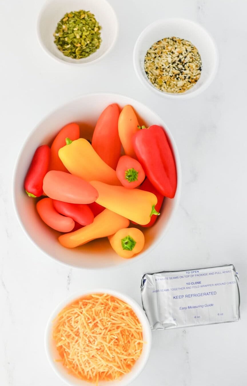 stuffed mini peppers ingredients in white bowls on a white surface