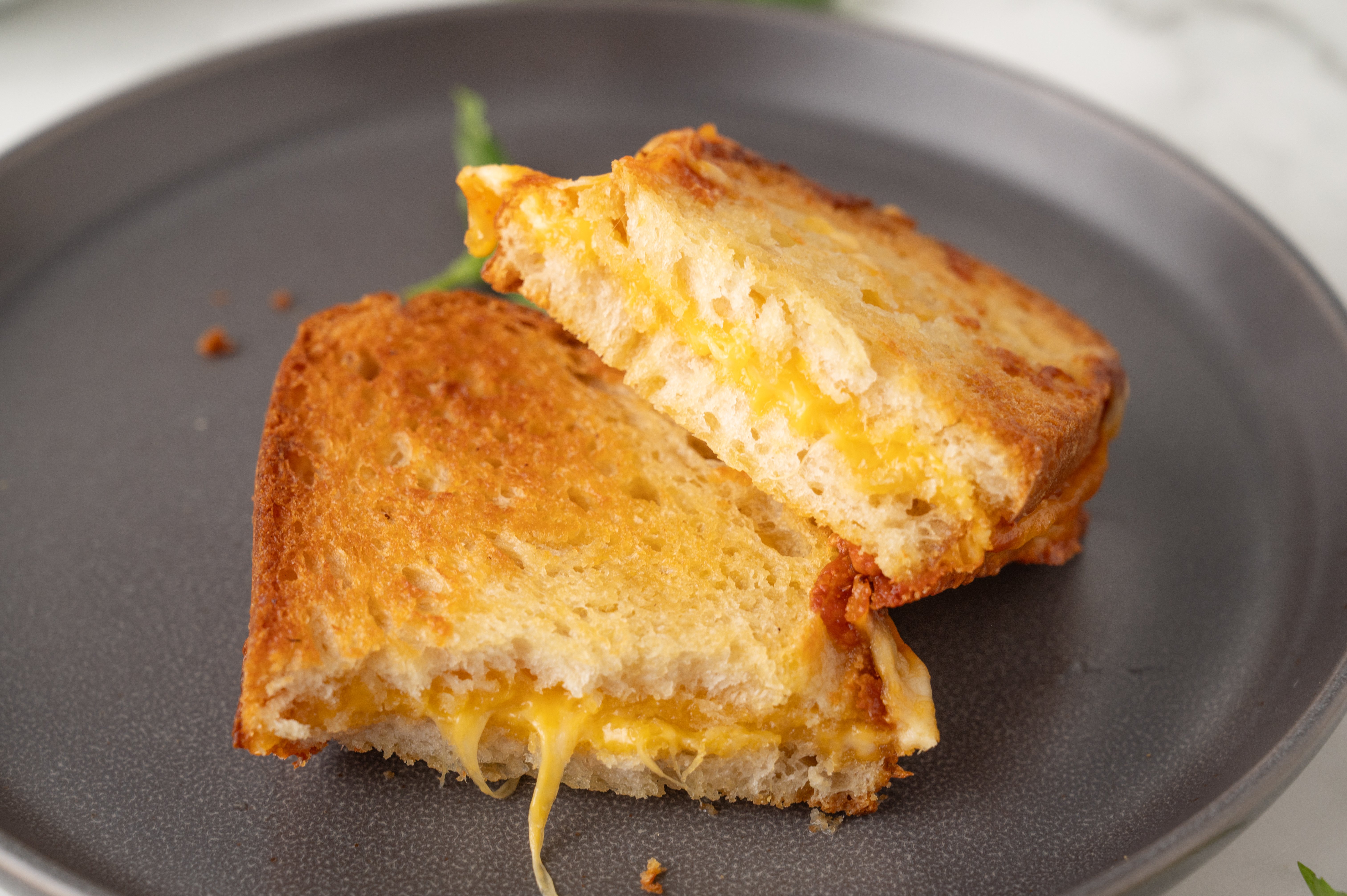 air fryer grilled cheese cut in half and stacked on a gray plate