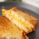air fryer grilled cheese sandwich cut in half on a plate