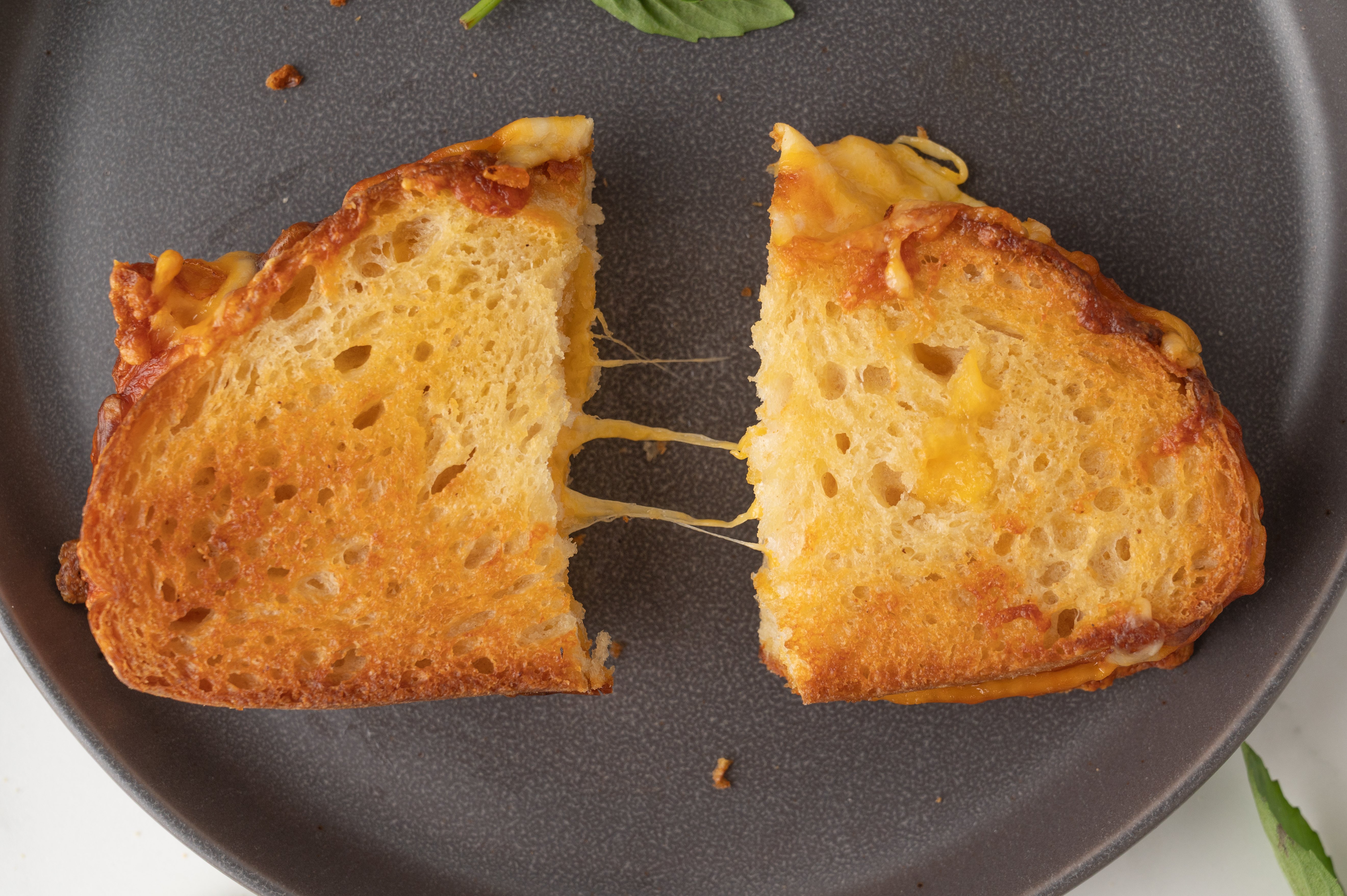 air fryer grilled cheese sandwich cut in half with cheese pull between the halves