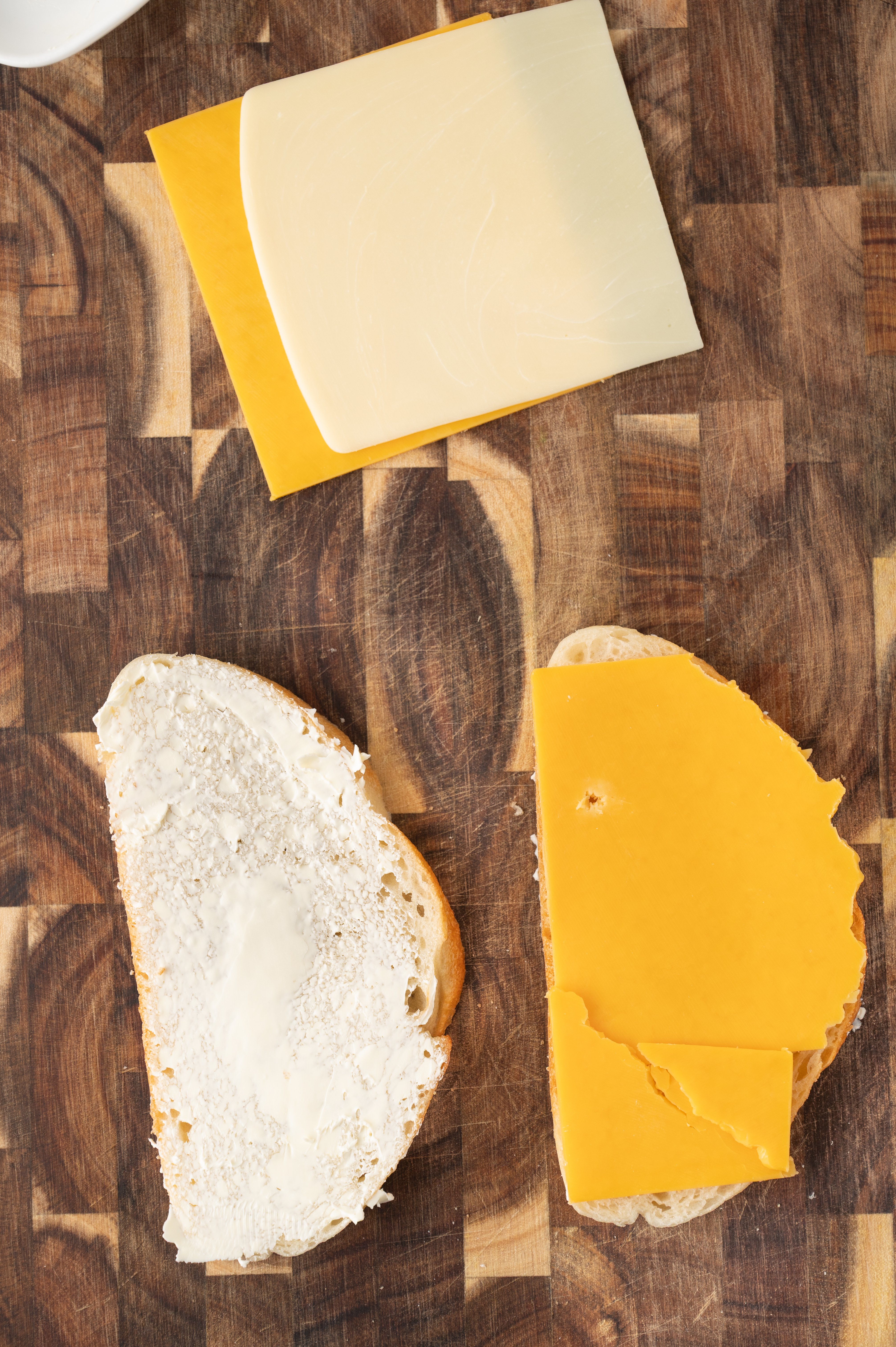 a slice of buttered sourdough bread and a slice with cheddar cheese on it