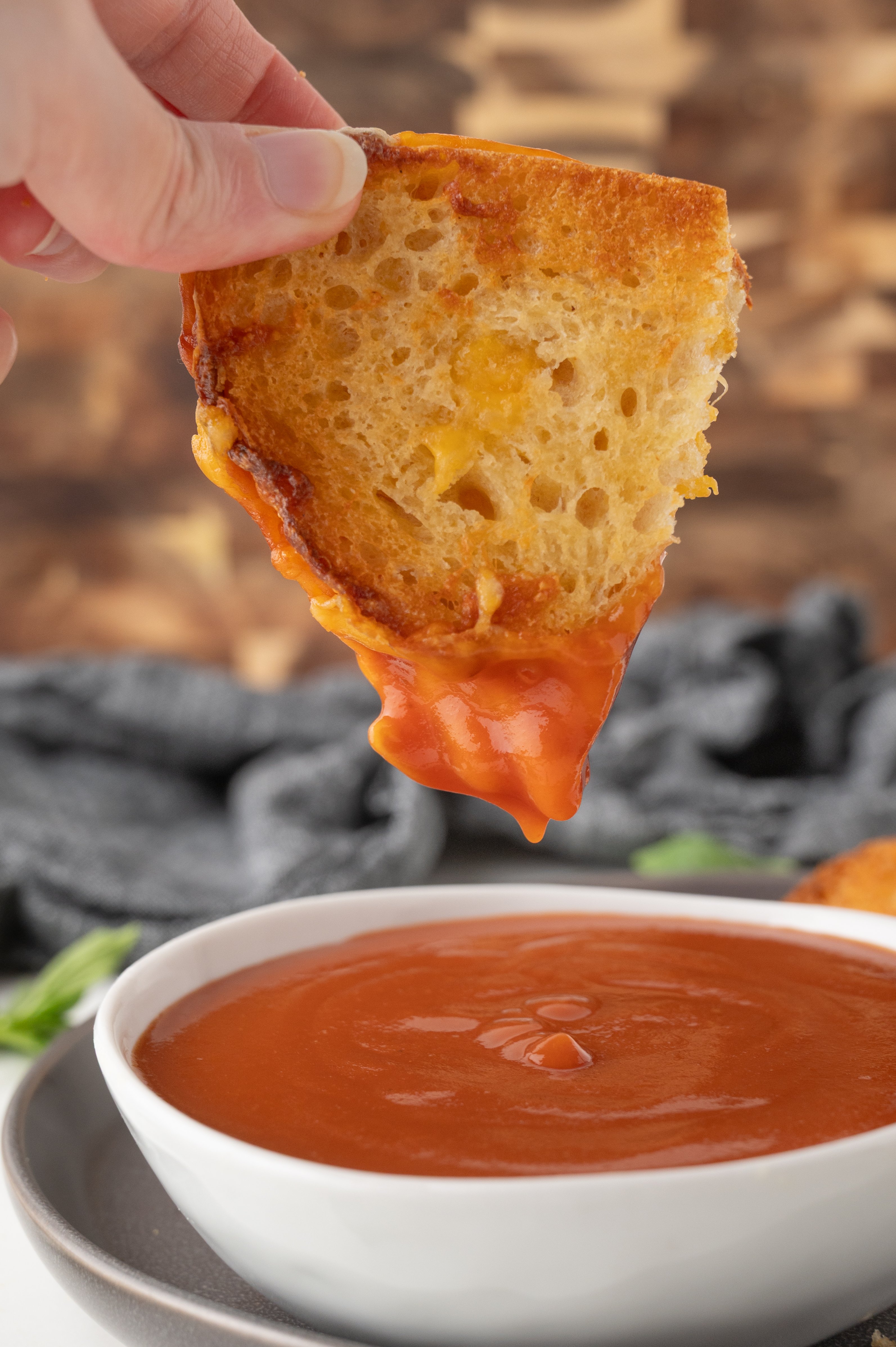 air fried grilled cheese sandwich half being dipped in tomato soup