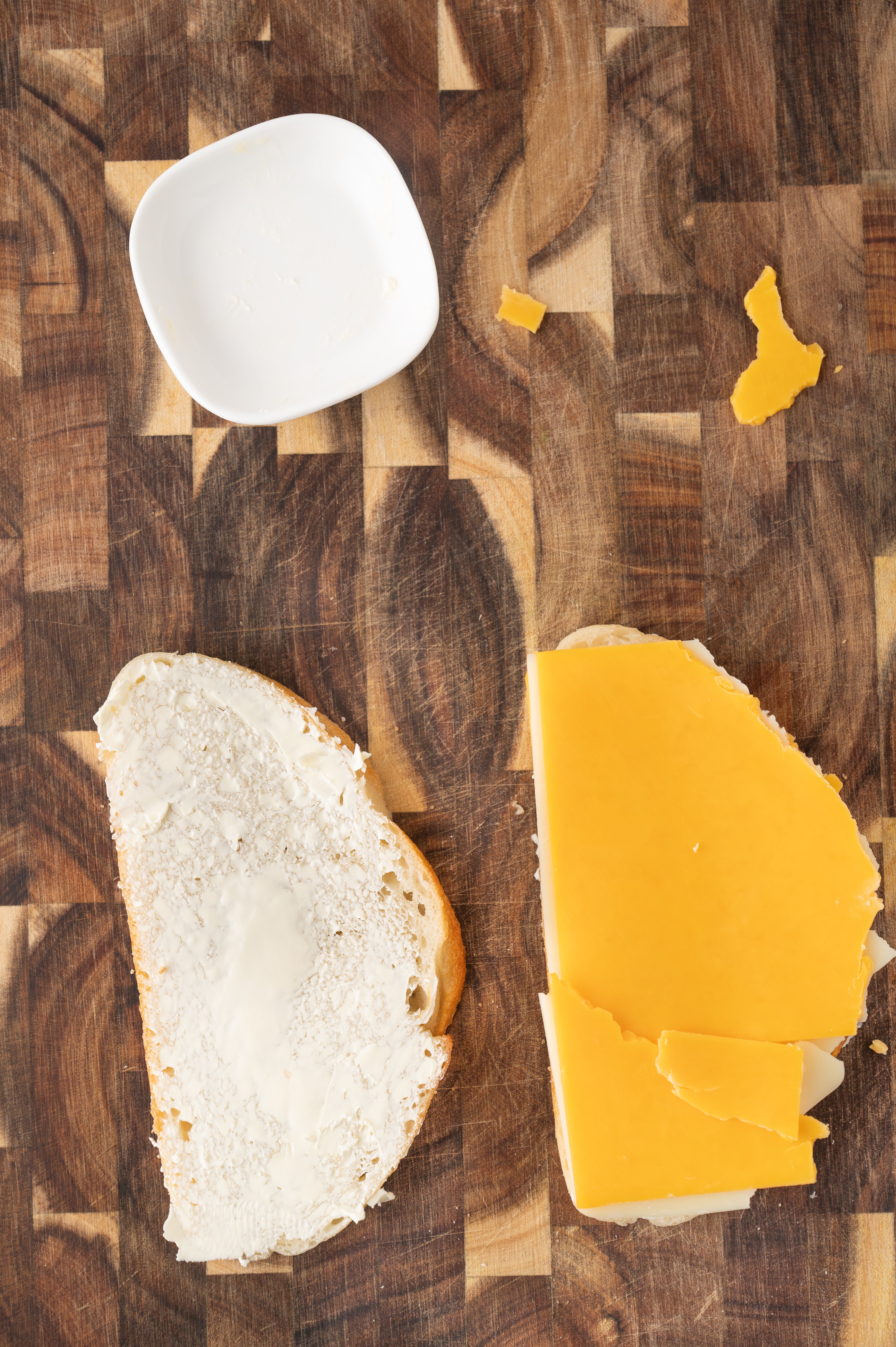 a slice of buttered sourdough bread and more cheddar cheese on top of a second slice
