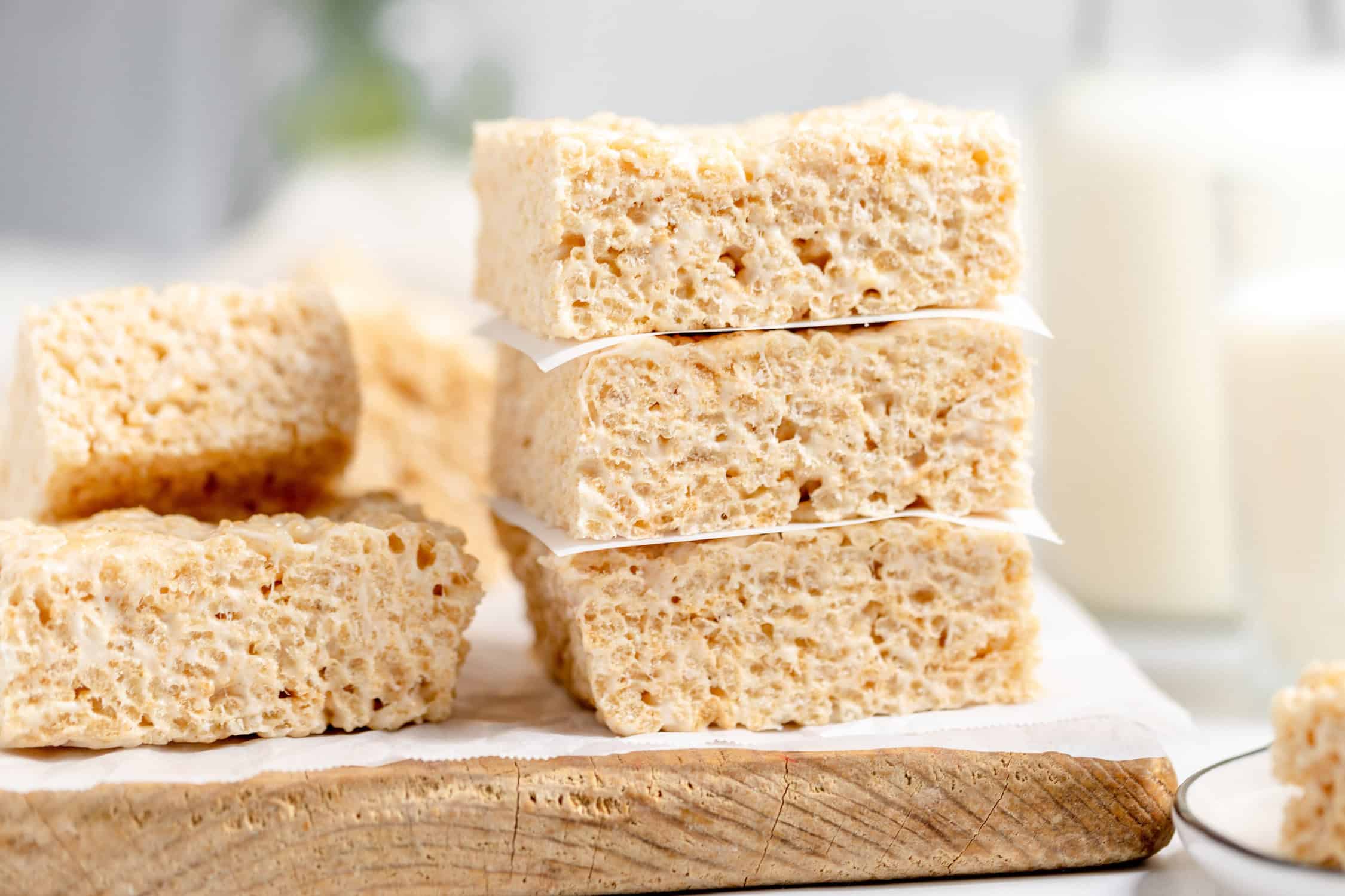 brown butter rice krispie treats cut into squares and stacked on a cutting board