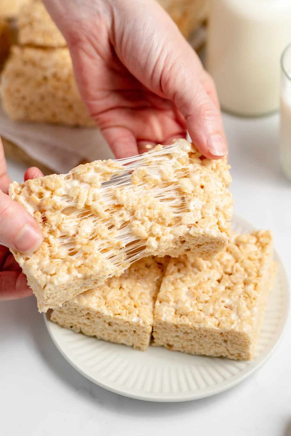 brown butter rice krispy treats being pulled in half with marshmallows
