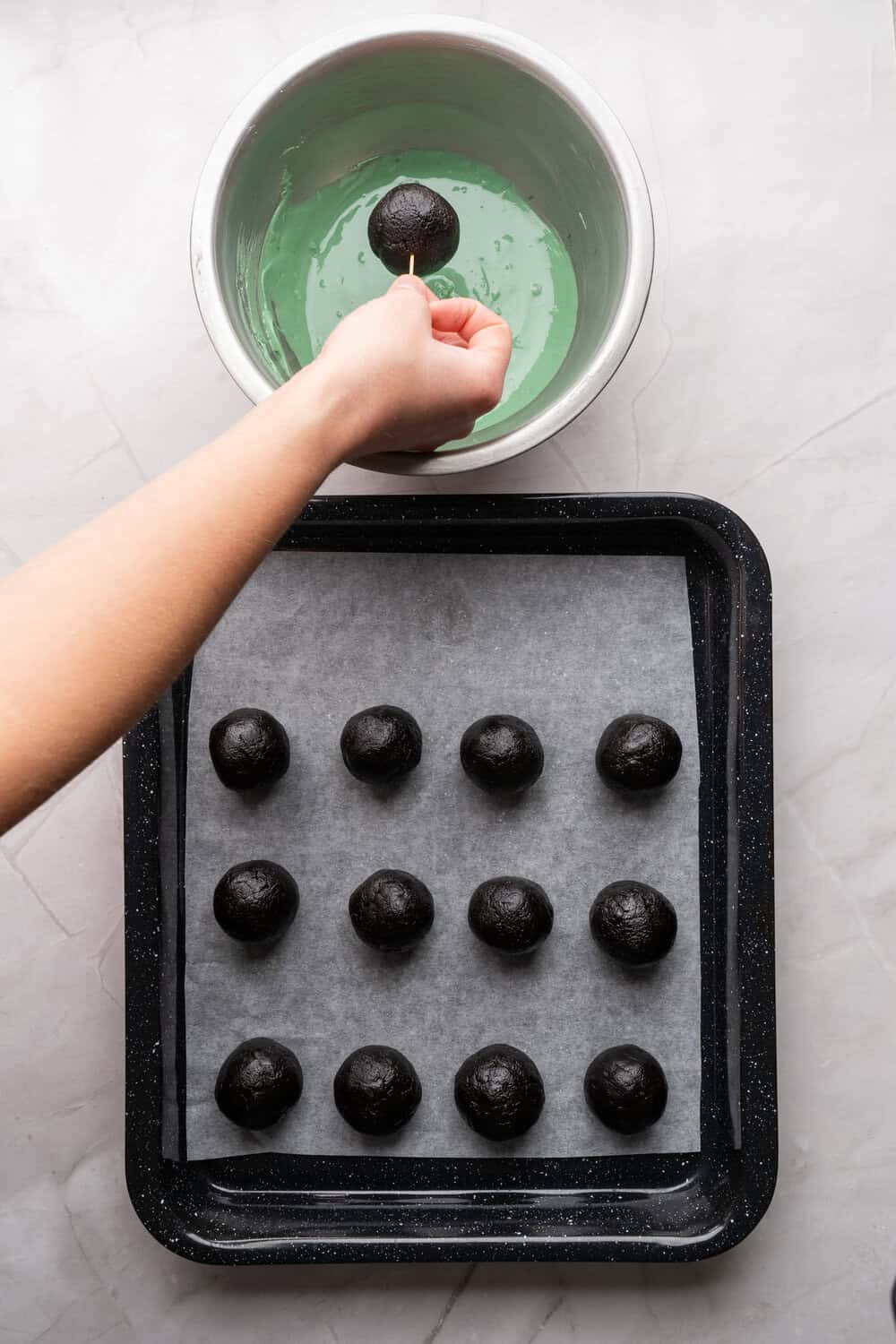 dipping oreo ball in melted green chocolate