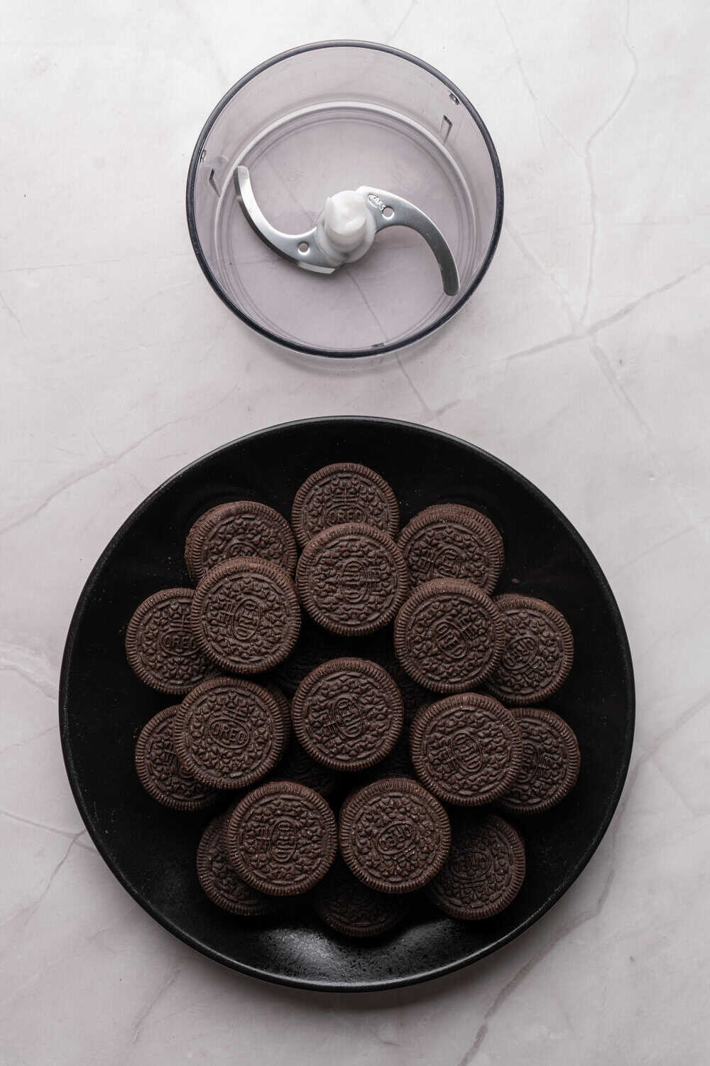 oreos on a black plate next to a food processor