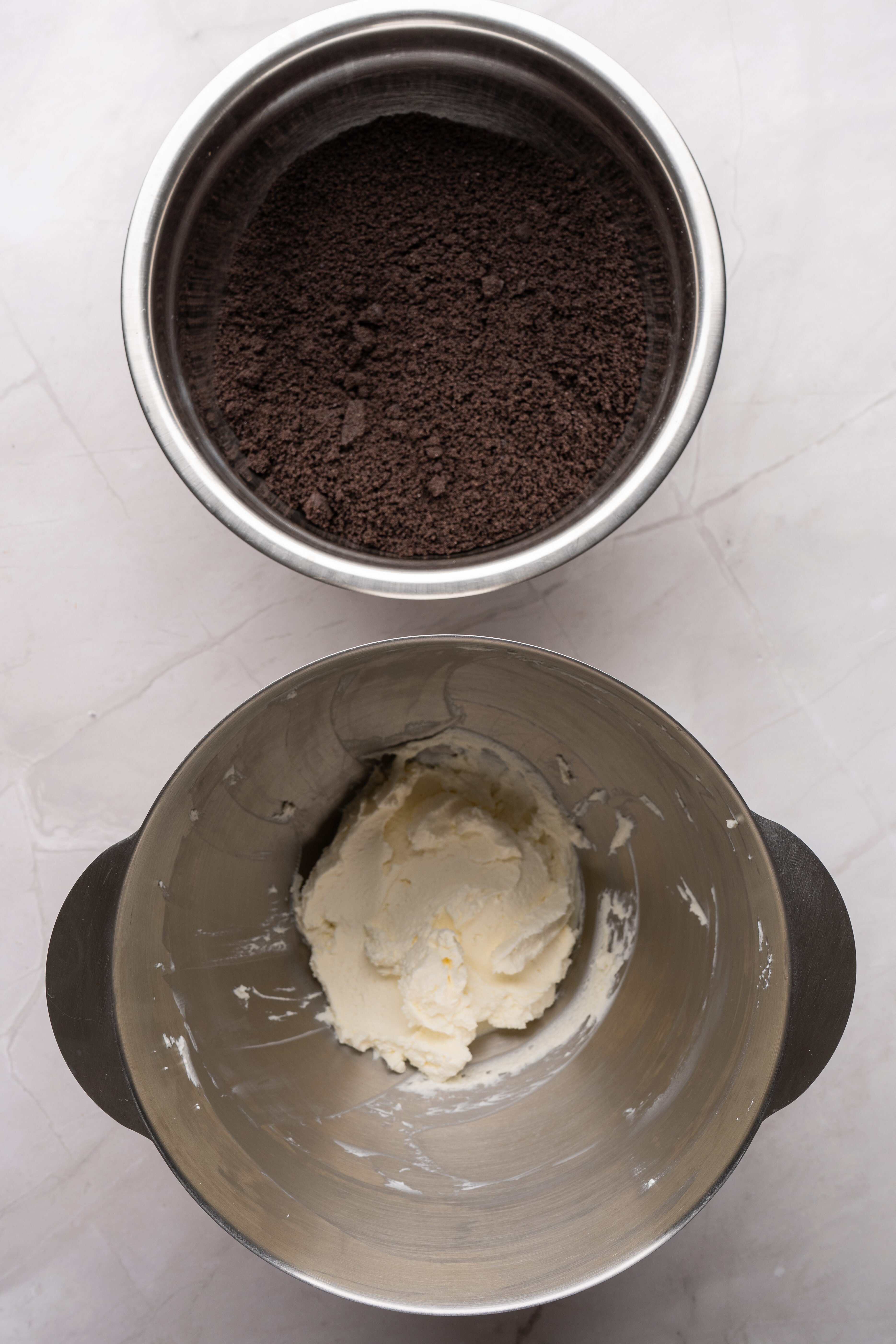 oreos in food processor next to bowl with softened cream cheese
