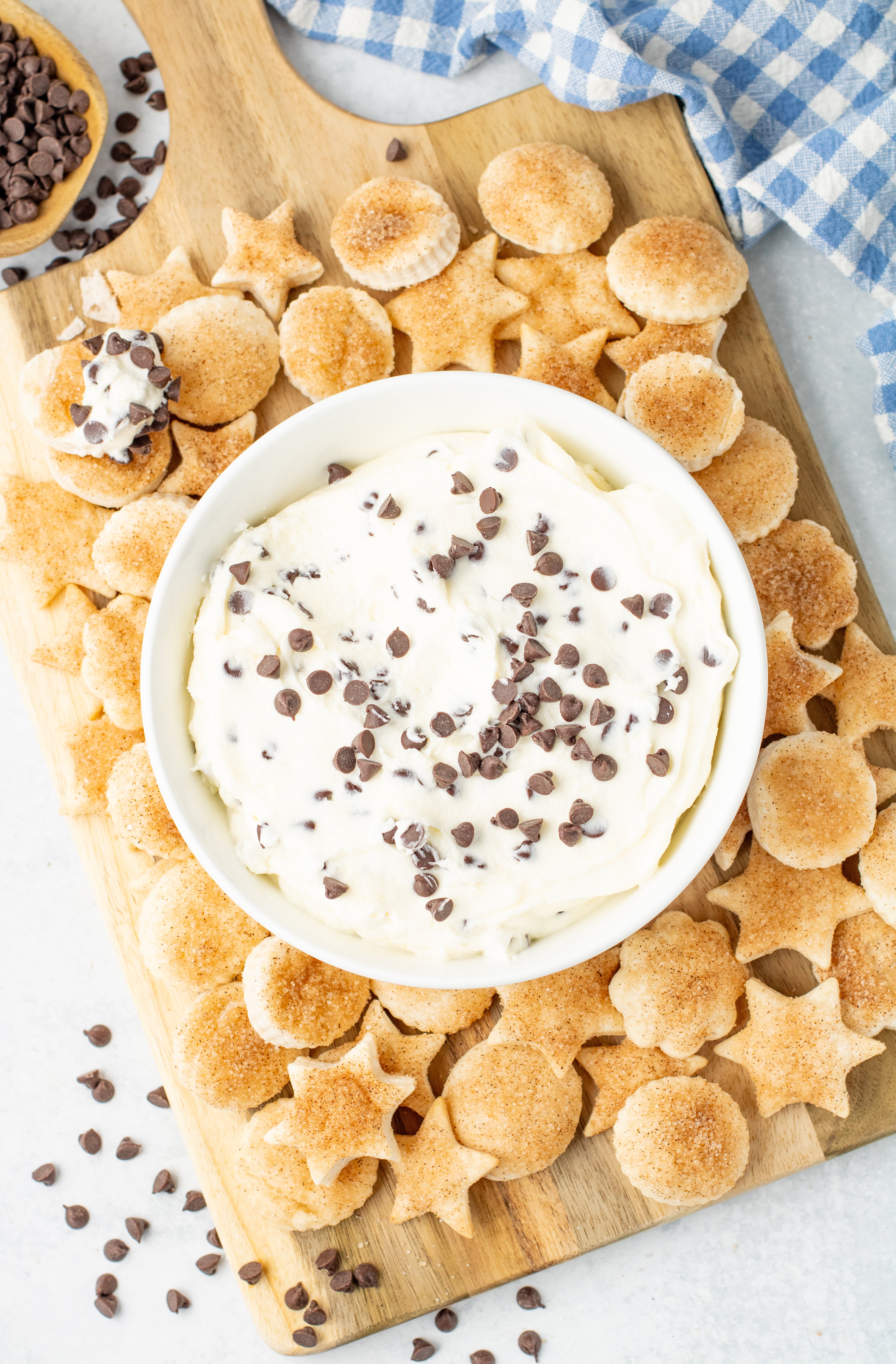pie crust cookies on a cutting board with a bowl of chocolate chip dip in the middle