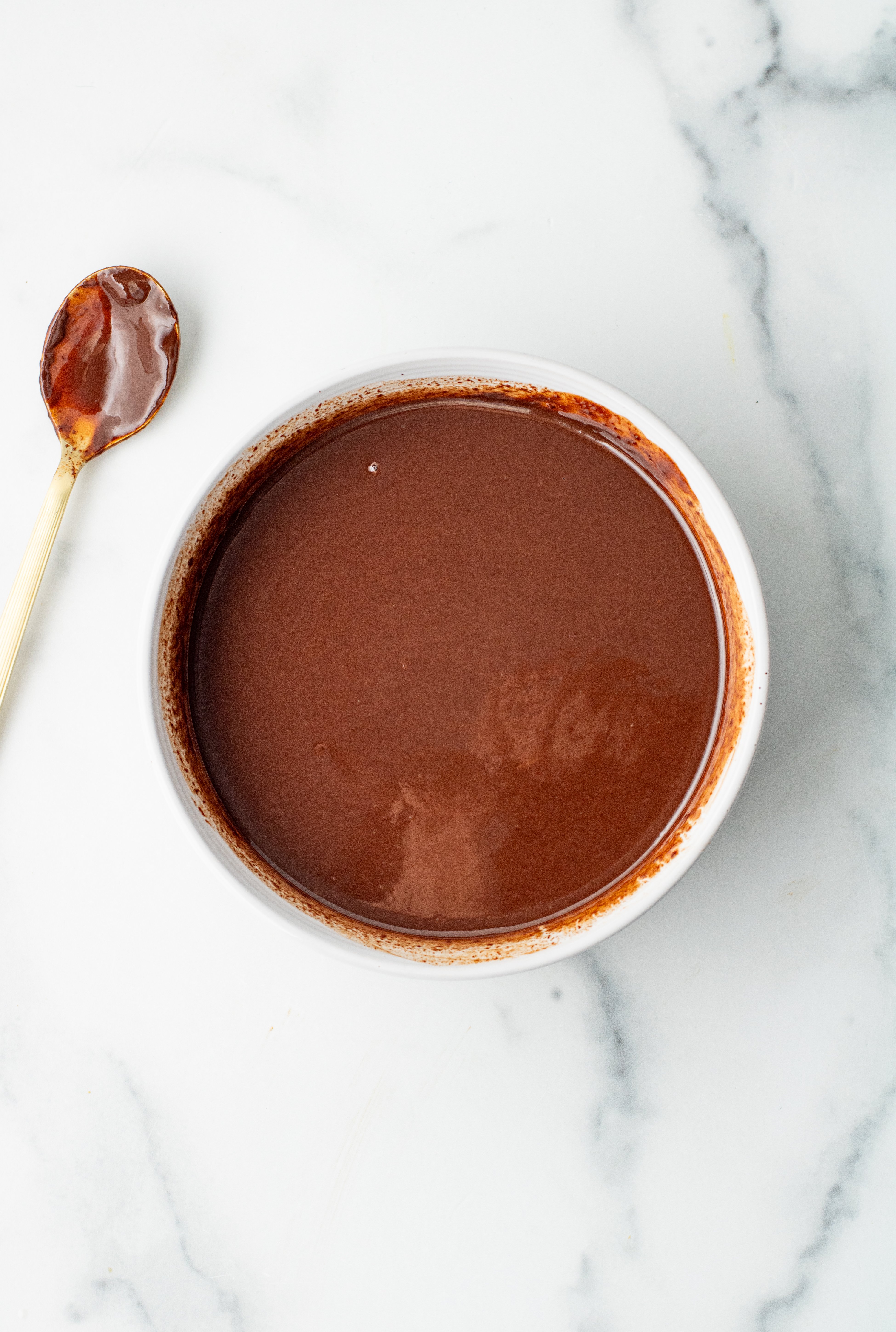 stirred up, finished chocolate ganache in a white bowl