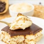 slice of chocolate eclair cake with a bite missing on a fork lying on top