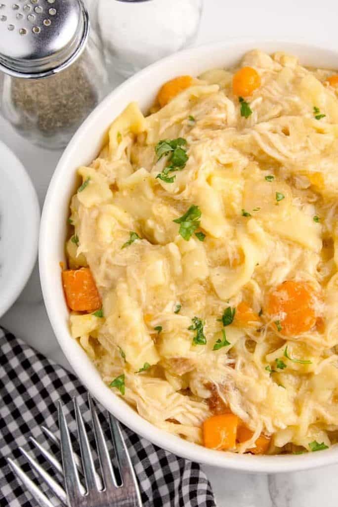 crockpot creamy chicken and noodles in a white bowl