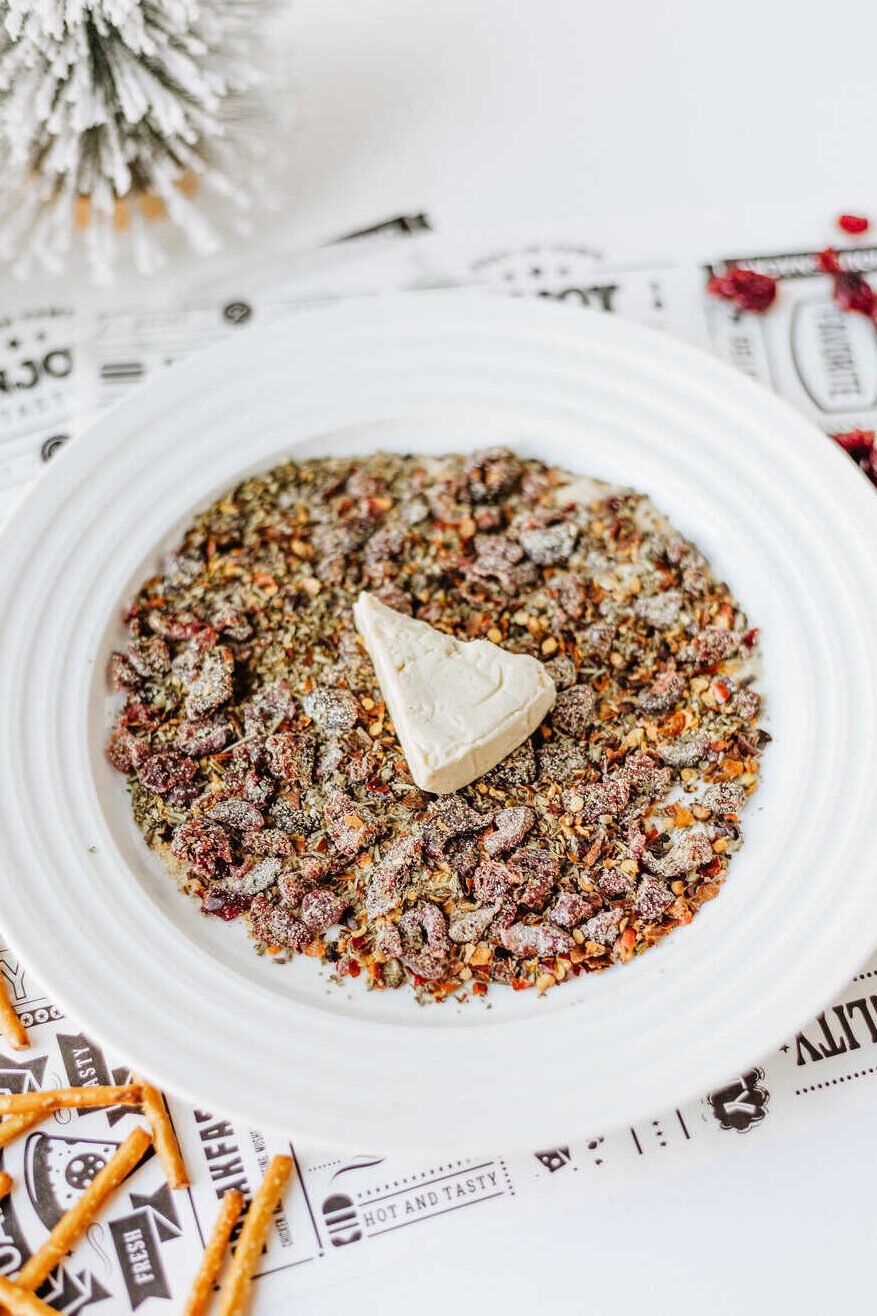 wedge of cheese on the mixed up spices and cranberries