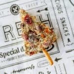 cheese wedge covered in spices, with a pretzel pressed into the bottom for a trunk