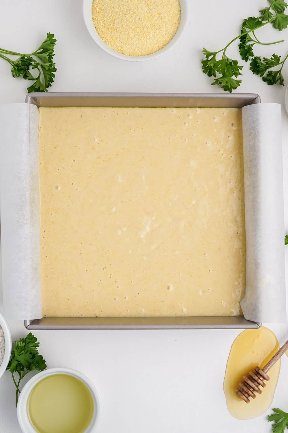 honey cornbread batter in a prepared square pan