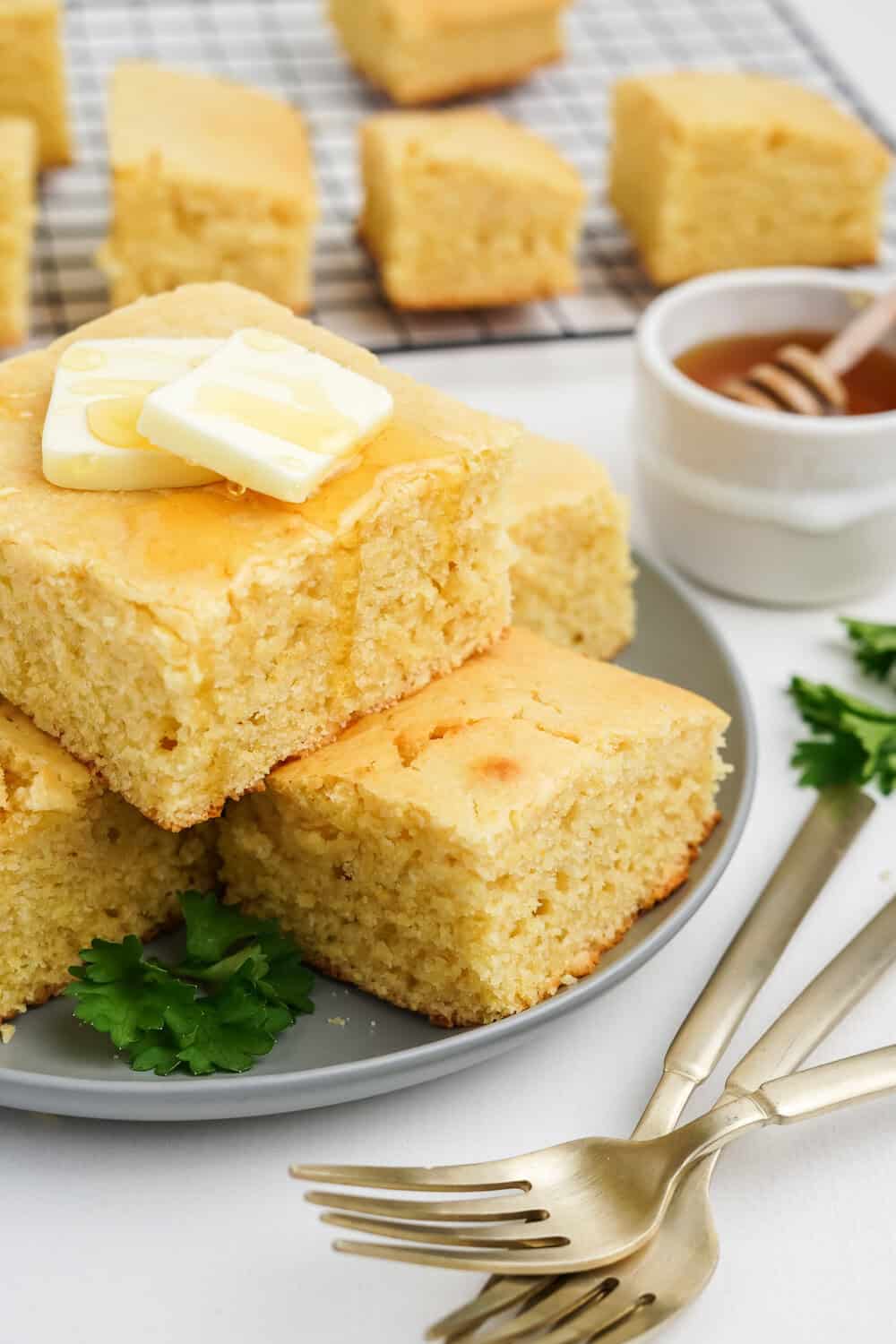 sweet honey cornbread with pats of butter and honey drizzled over the top