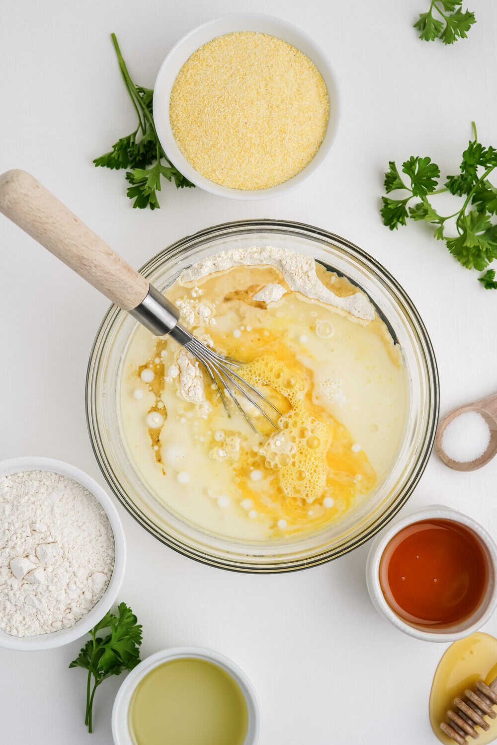 wet ingredients added to mixing bowl whisked together for honey cornbread