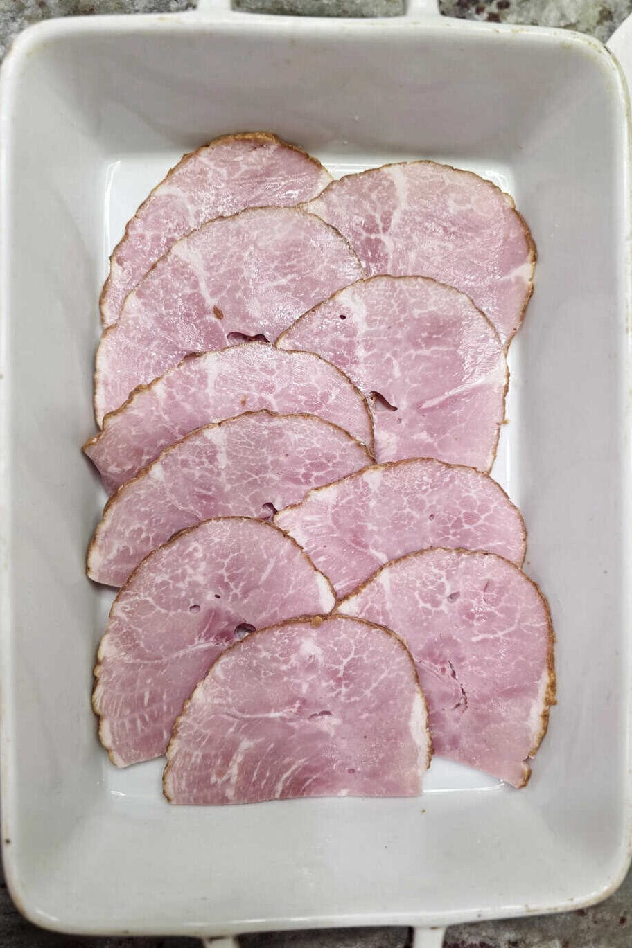 sliced ham in a layer in a baking dish