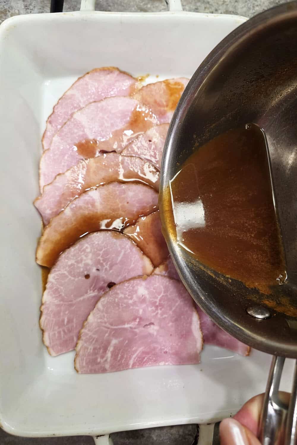 pouring glaze over sliced ham
