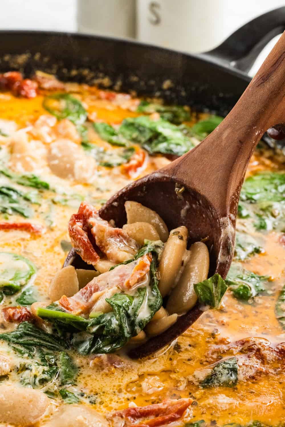 Marry Me Butter Beans being dipped with wooden spoon