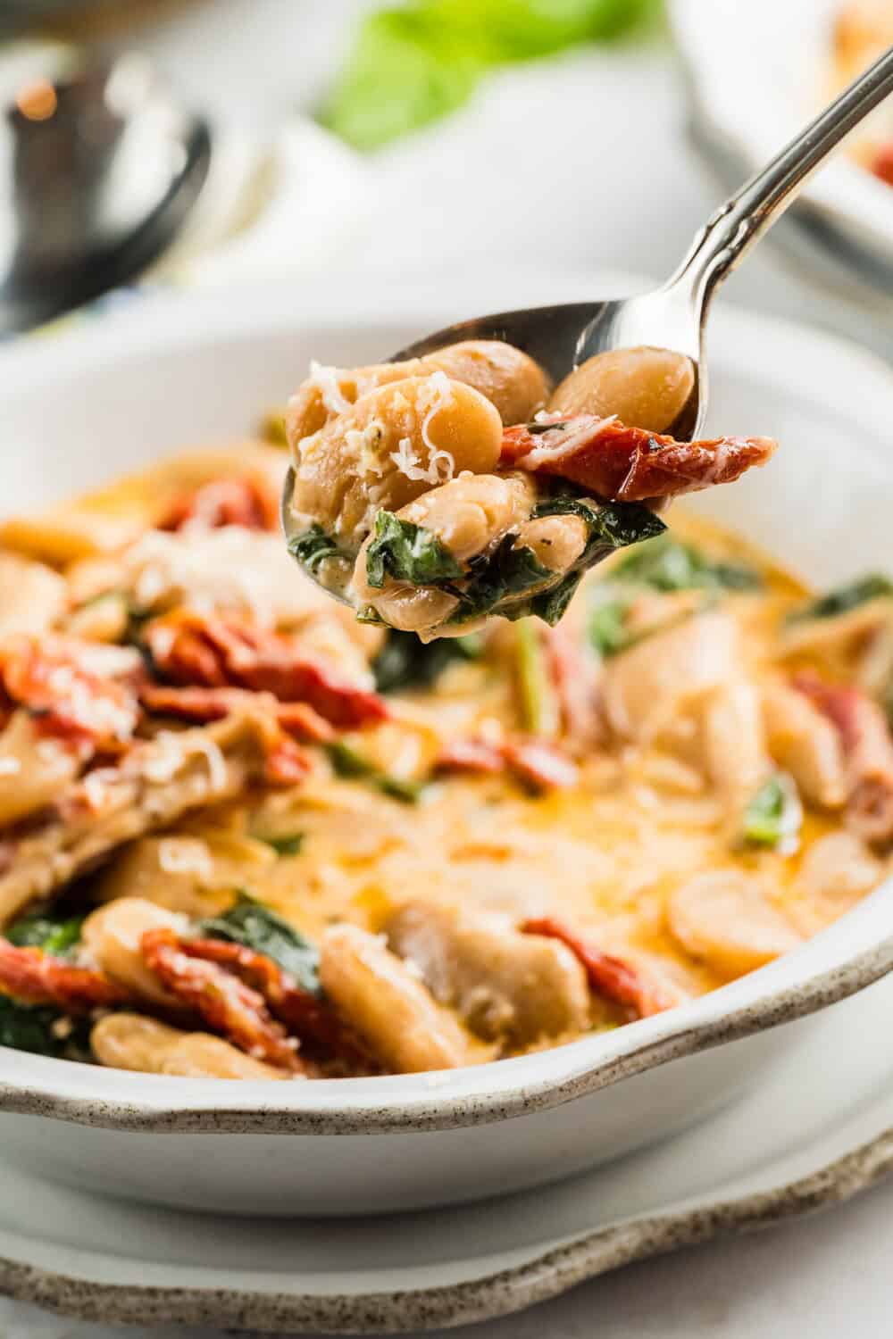 marry me butter beans in a white bowl with a spoon