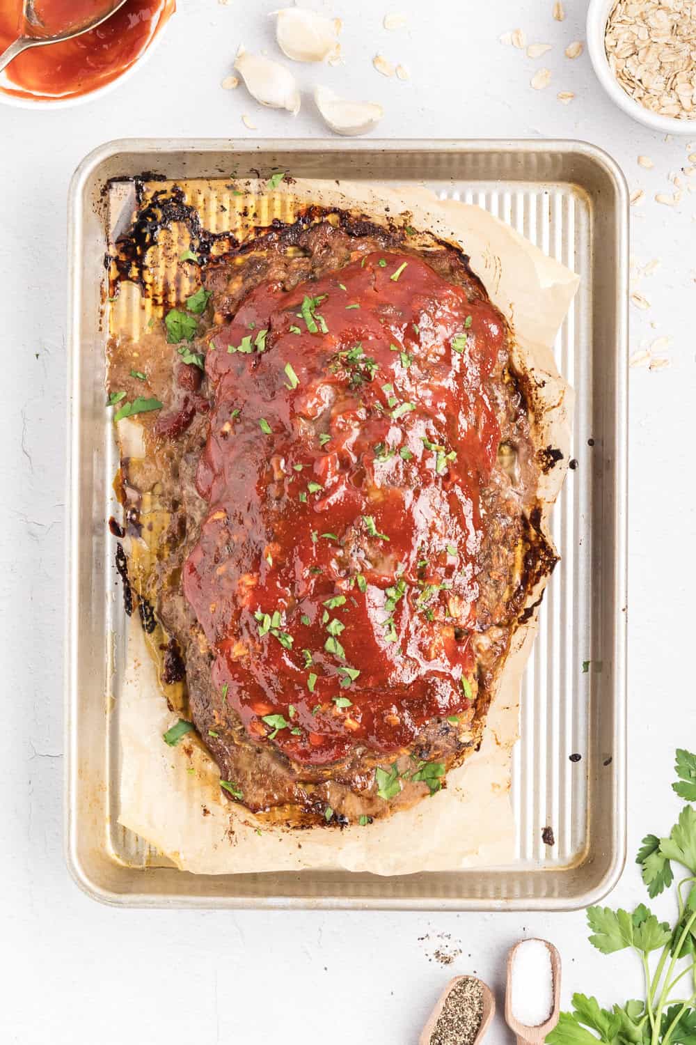 chopped parsley sprinkled over baked meatloaf topped with meatloaf sauce