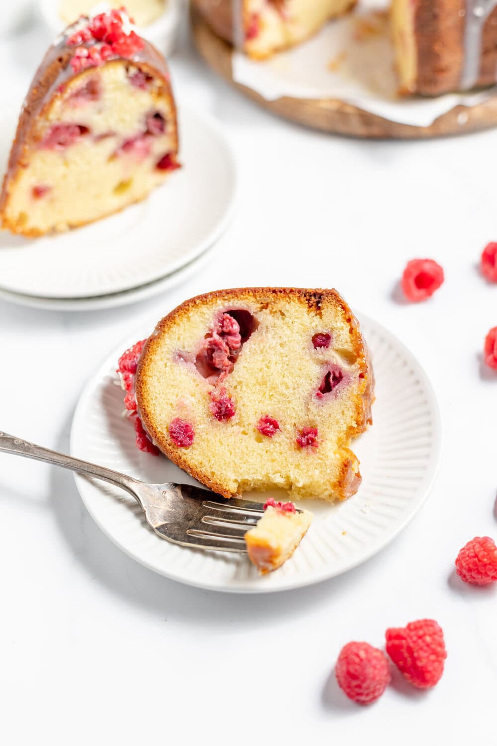 slices of White Chocolate Raspberry Bundt Cake on individual white plates