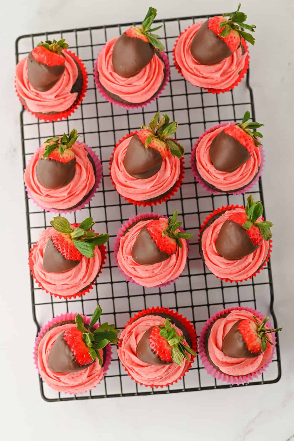 chocolate cupcakes with strawberry frosting and a Chocolate Covered Strawberry