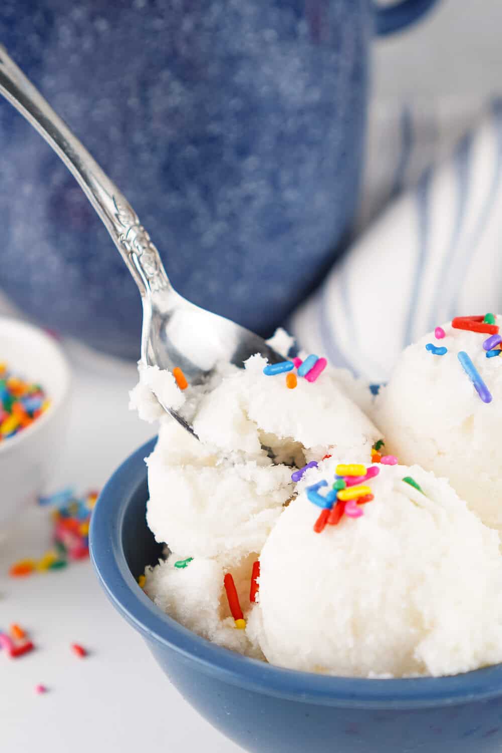 snow ice cream with sprinkles being dipped with a spoon