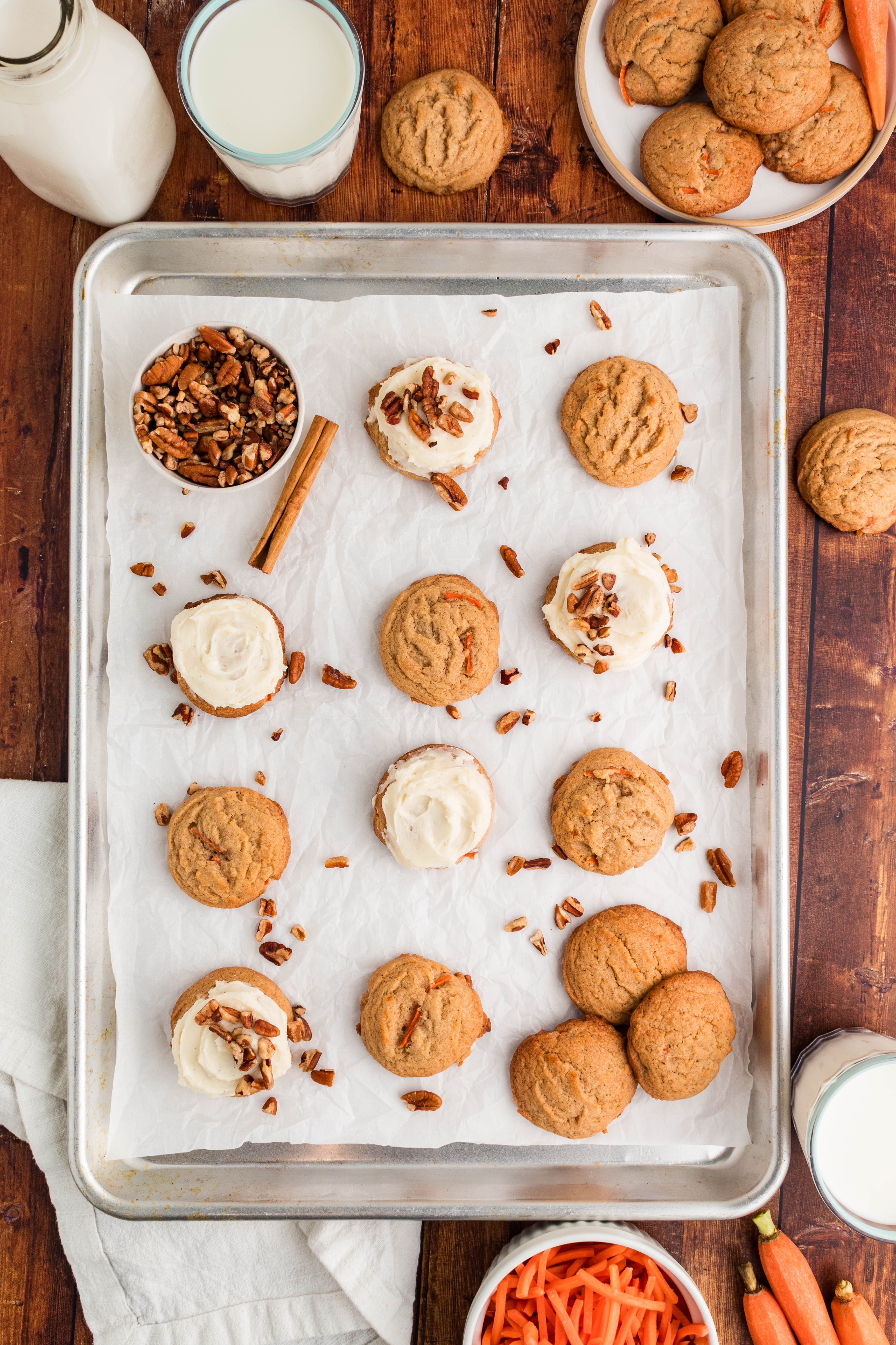 cookie sheet with carrot cake cookies - some frosted, some plain, with nuts scattered