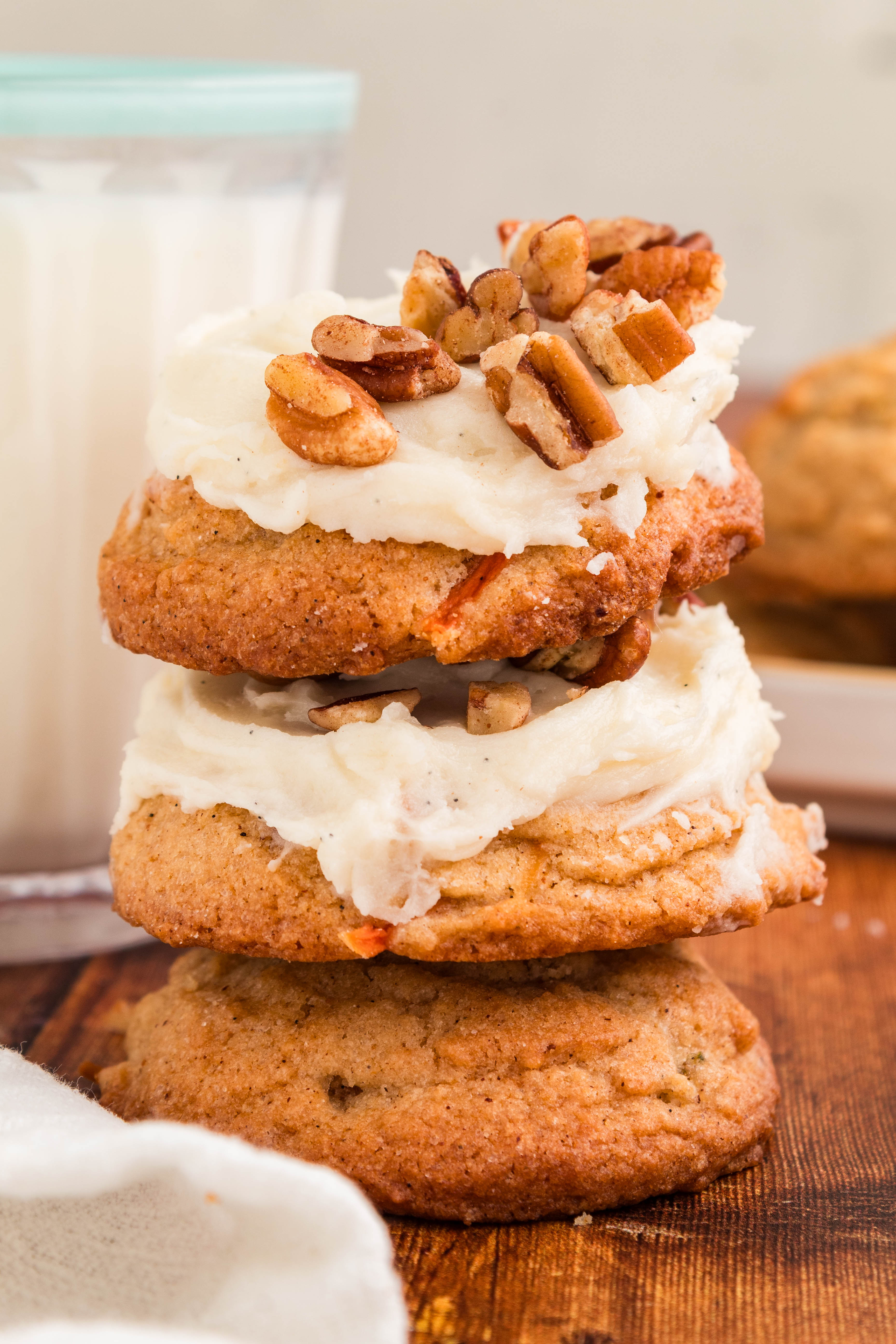 carrot cake cookies stacked with cream cheese frosting on them