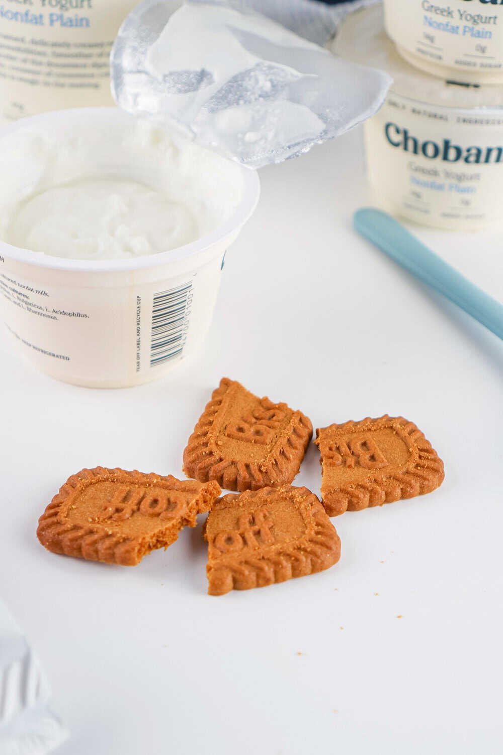 broken biscoff cookies next to cup of greek yogurt