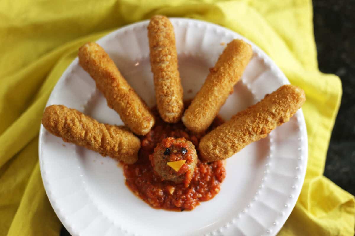 the turkey face is added with cheese wedge and olive eyes