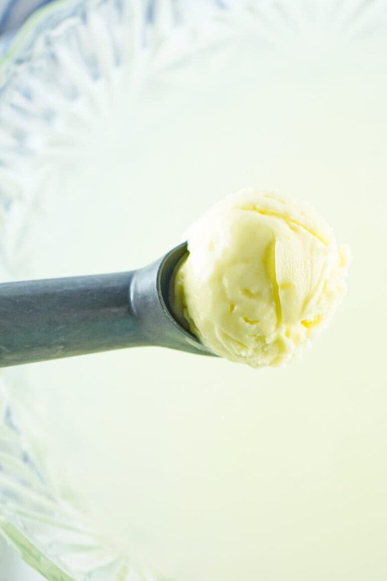 scooping pineapple sherbet into punch bowl