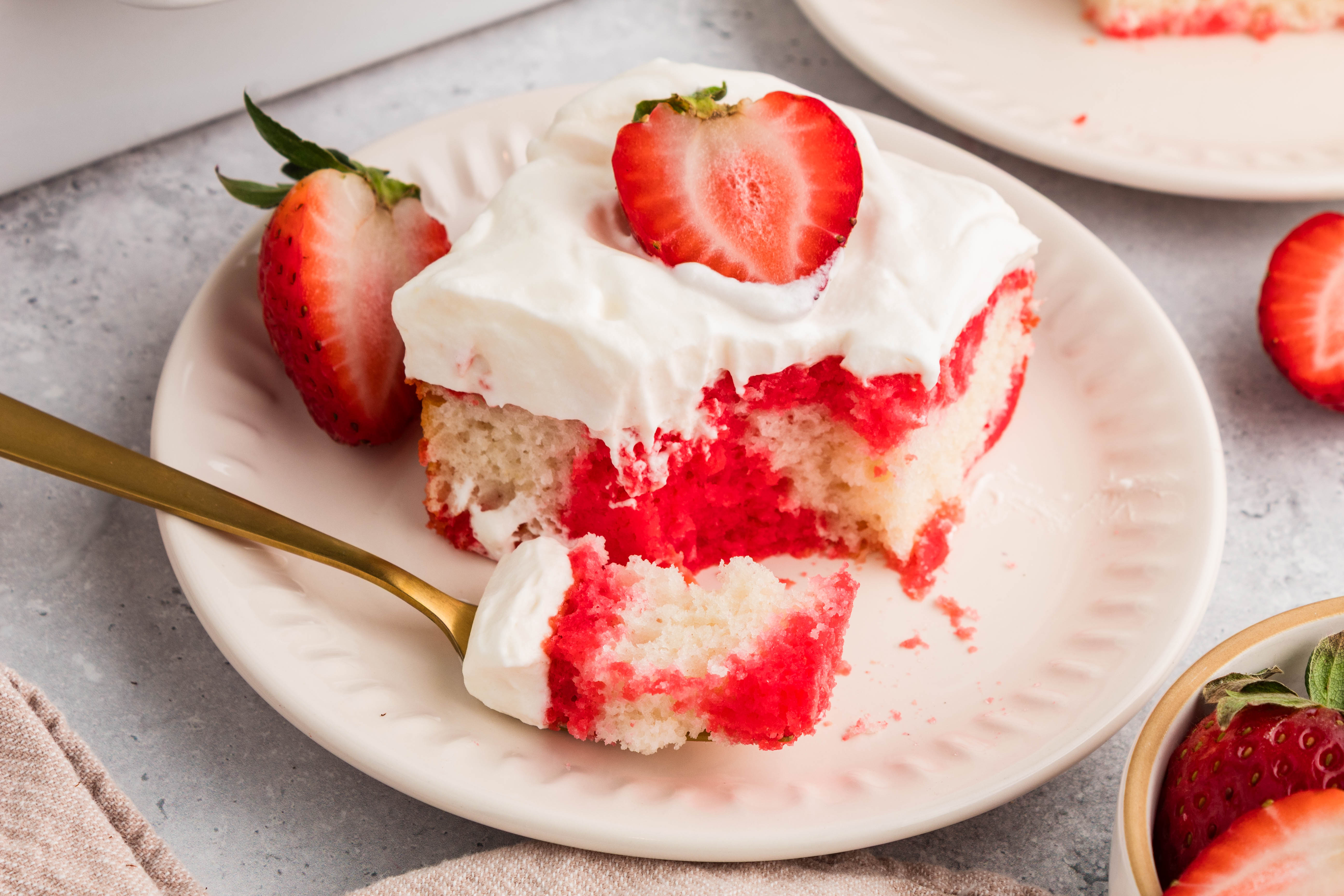strawberry jello poke cake with a bite on a fork