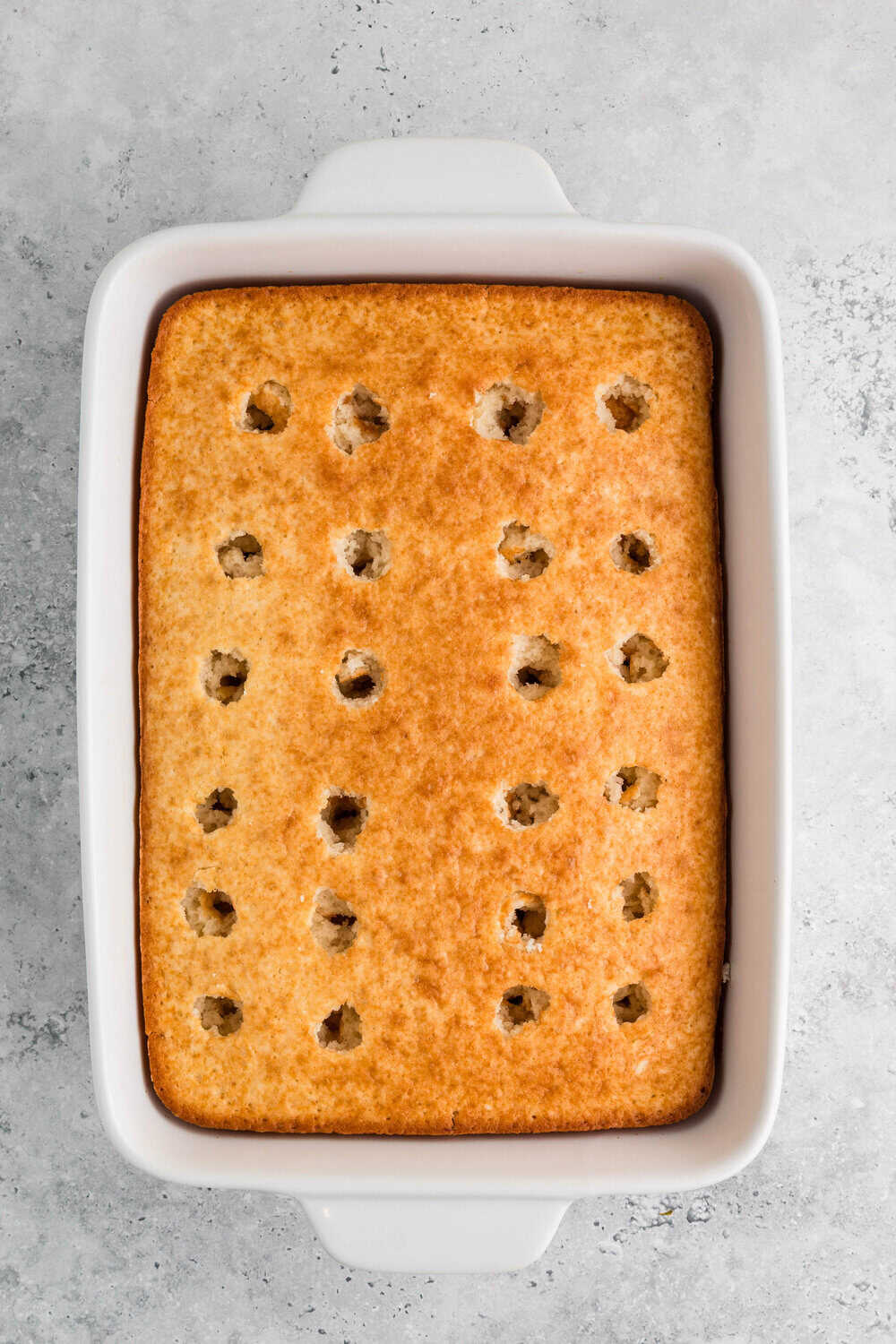 sheet cake in 9x13 pan with holes poked in it