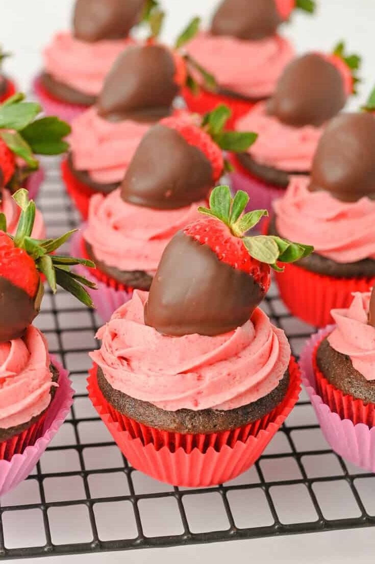 Chocolate cupcakes with strawberry frosting on a wire rack