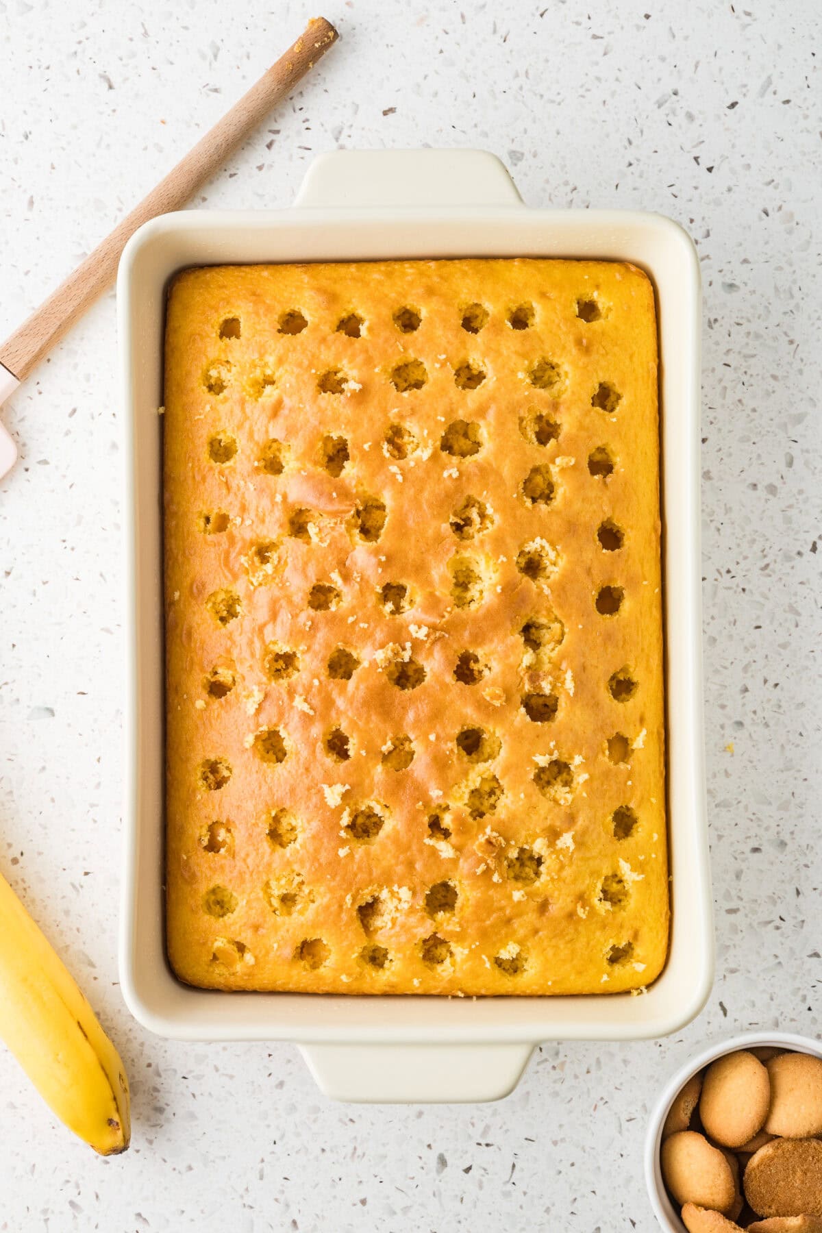 9x13 cake in a baking dish with holes poked in it